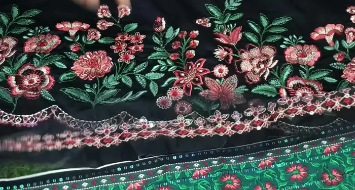 Floral embroidered border on black fabric, with a printed border below